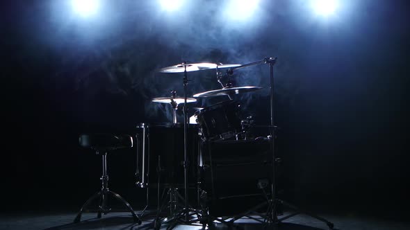 Professional Drum Set with Chair. Black Smoky Background. Back Light. Side View