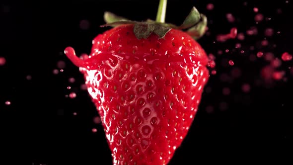 Strawberry Slice Falling and Splashing on Black Background