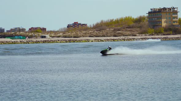 A Jet Ski Runs Across the Sea in Front of a Dike