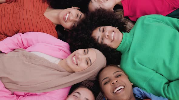 Multiethnic female friends having fun lying together in circle