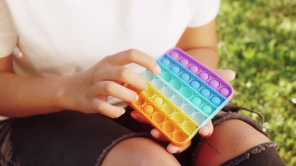 Black Teenage Girl Holding POP IT Fidget Toy Antistress in Hands