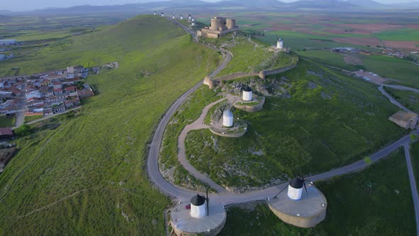 Scenic top aerial view of old windmills and castle on top of hill at sunrise, Spanish historical tou