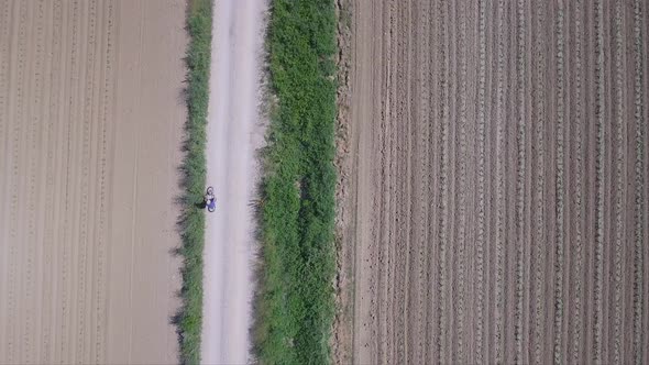 Man cycling in a countryside road, Aerial view