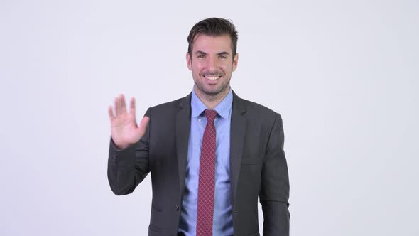 Young Happy Hispanic Businessman Waving Hand