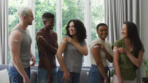 Group of diverse young people showing their vaccinated shoulders at home