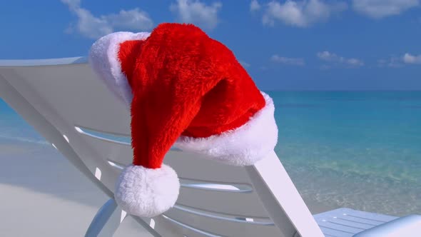 Santa Claus Hat on Sunbed Near Tropical Calm Beach with Turquoise Sea Water and White Sand