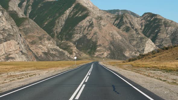 Motion On Highway Going To Rocky Mountain Range Through Desert Prairie
