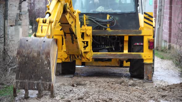 The Tractor Works During the Restoration of the Loosening Crushed Stone Road