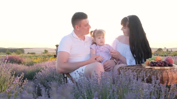 Beautiful Young Family on a Picnic in a Lavender Field