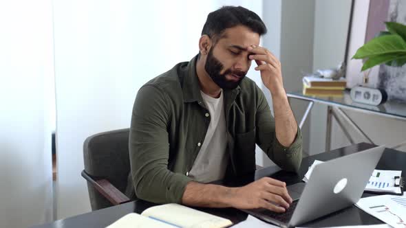 Pensive Indian or Arabian Man in Casual Clothes Freelancer Designer Stock Broker Sitting in Modern