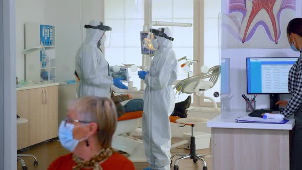 Doctors in Full Virus Protection Uniform Talking in Surgery Room