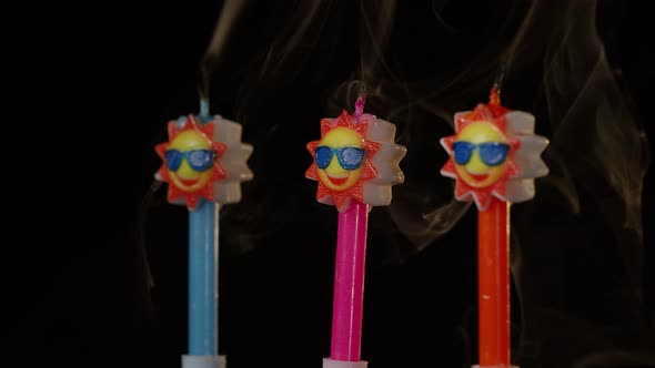 Birthday Festive Candles in Form of Sun in Sunglasses Turning Spinning Isolated on Black Background