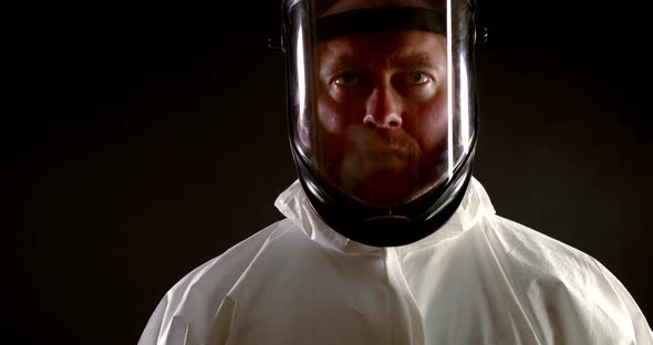 A Virologist Is a Scientist in Protective Clothing. Portrait of a Tired Puzzled Man in a Helmet