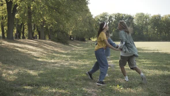 Wide Shot Carefree High Hippies Jumping Circle Holding Hands