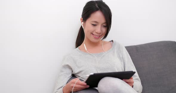 Woman watching on digital tablet computer at home 