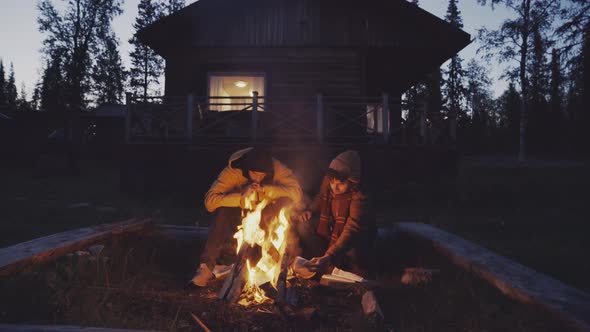 Men sitting near fire in countryside