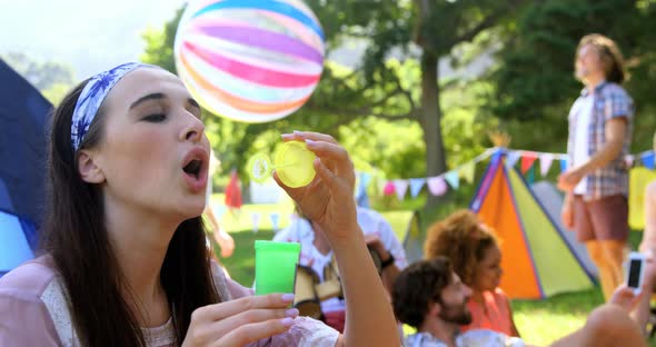 Hipster woman doing soap bubble with a toy