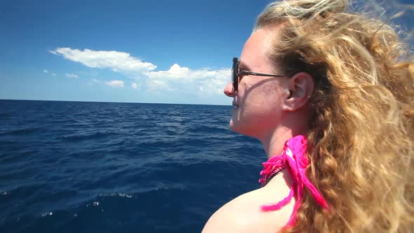 Woman sitting on bow of sailing boat enjoying view of sea