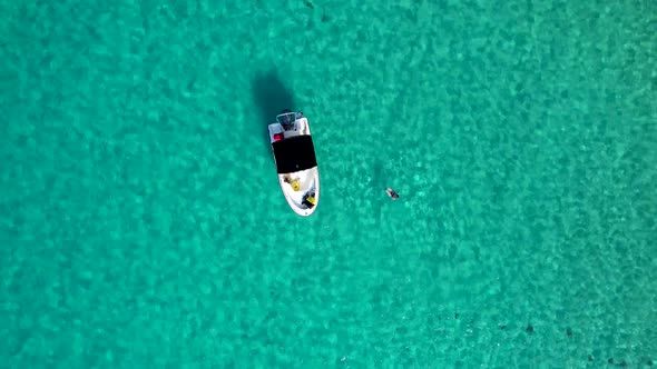 Speed boat In tropical blue Jamaica water with woman swimming