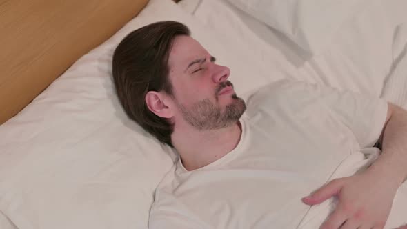 Casual Young Man Laying in Bed Unable to Sleep