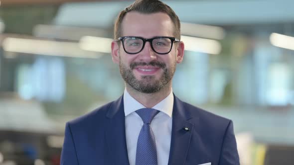 Portrait of Middle Aged Businessman Smiling at Camera