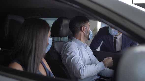 Masked Couple Enjoying Sitting in New Bought Car