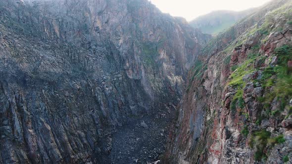 Big Brown Sharp Cliffs with Grass on Top and River in Canyon