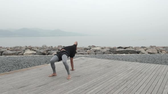 Young mixed race man doing animal flow by the sea