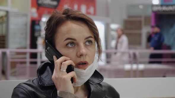 A Business Woman in a Protective Mask Communicates in a Shopping Center