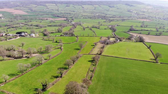 Aerial forward shot of the East Devon Countryside on a sunny day with the Blackdown Hills in the dis