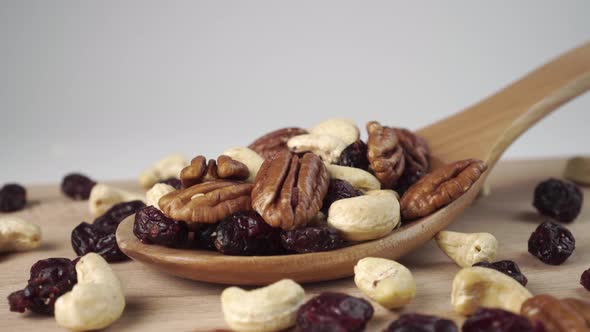 Ingredients of a nutty fruit mixture in a wooden spoon on a board