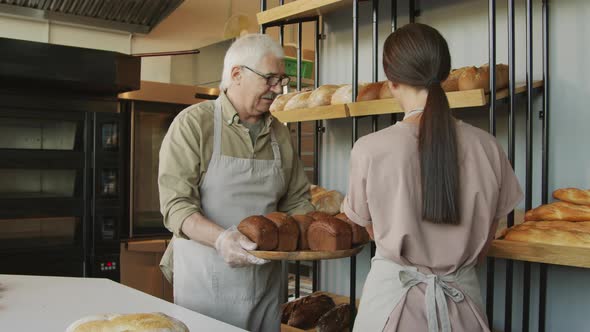 Bakery Employees Putting Fresh Bread on Shelf