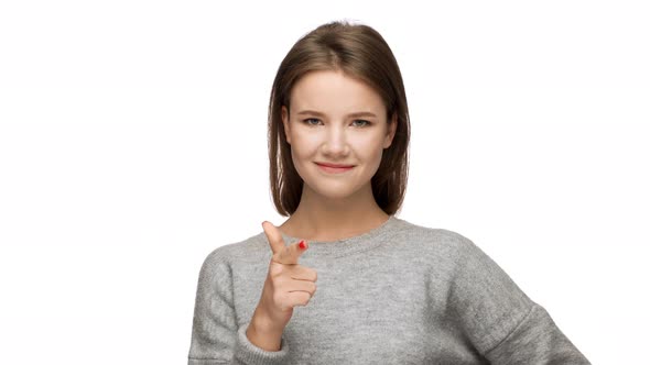Portrait of Cheerful Nice Female 20s in Casual Sweatshirt Gesturing Finger on Camera Meaning Hey you