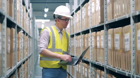 Storage Worker in Safety Wear is Registering Parcels