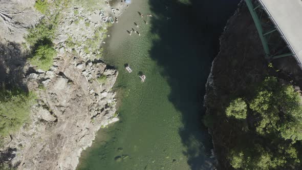 Drone shot from above of people playing in a blue green river