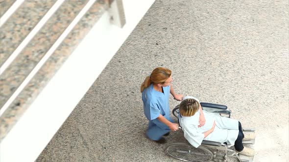 High angle view of a nurse wheeling a patient in a wheelchair