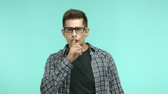 Brunette Man in Glasses Cant Hear Anything Shaking Head Confused and Making Shush Sign Hushing at