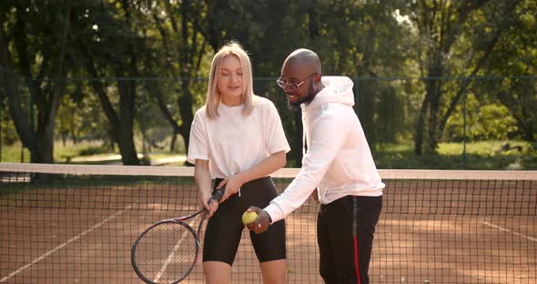 Black Race Tennis Instructor Teaches Girl to Play