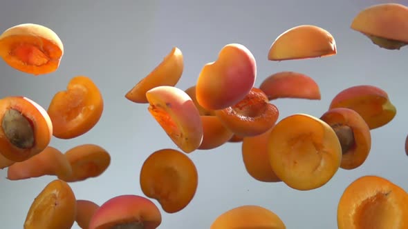 Tasty Apricot Halves Bounce on a White Background