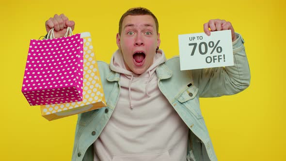 Cheerful Teen Man Showing Shopping Bags and Up To 70 Percent Off Inscriptions Banner Black Friday