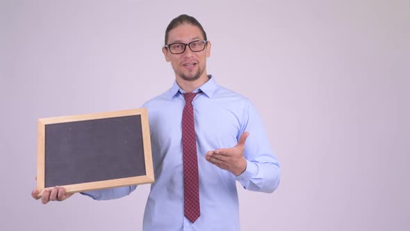 Happy Handsome Businessman Holding Blackboard and Giving Thumbs Up