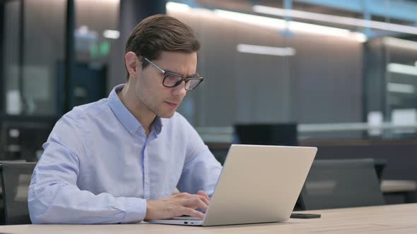 Young Man Feeling Shocked While Using Laptop