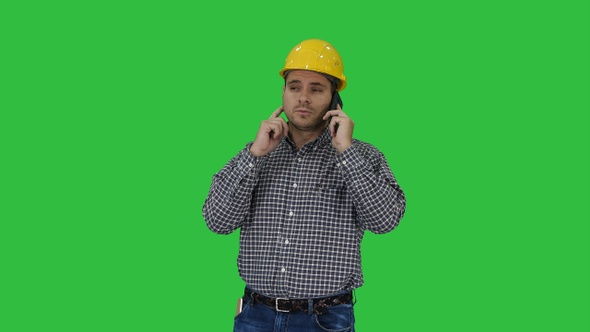 Construction worker using smartphone on a Green Screen, Chroma Key.
