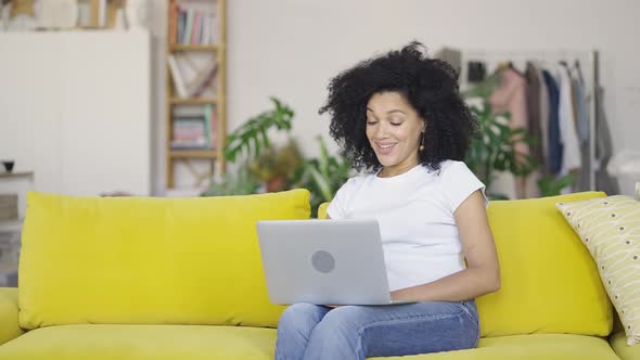 Portrait of a Young African American Woman Talking on a Video Call on Portable Laptop