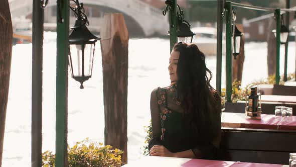 Woman in Cafe. View on Venetian Chanal in Venice, Italy