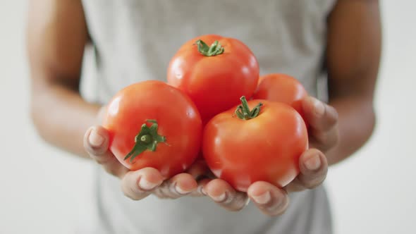 Video of biracial man holding fresh red tomatoes