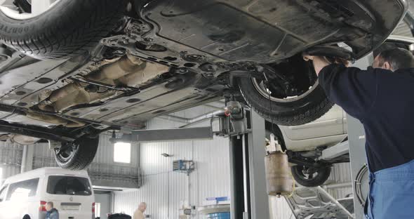 Mechanic Draining Old Brake Fluid From A System During The Service.