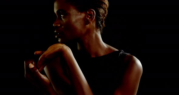 Androgynous man posing against black background