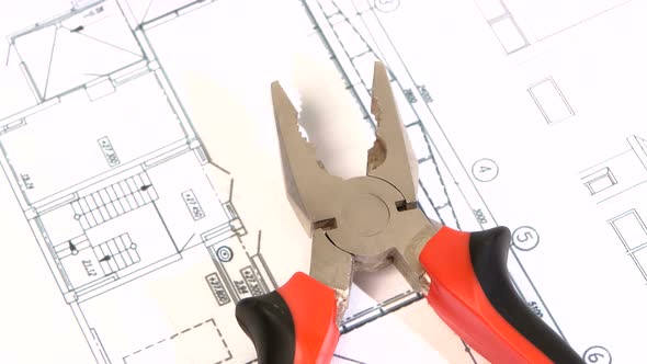 Gray and Red Pliers on Building Plan, Scheme, Rotation, Close Up