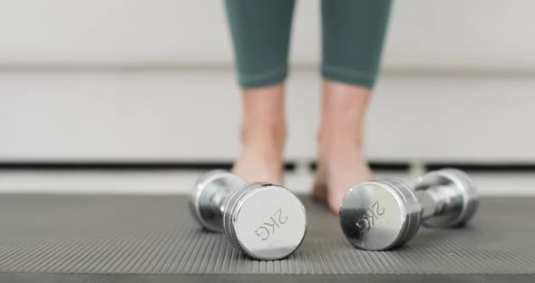 Closeup of Woman's Legs Near the Yoga Mat